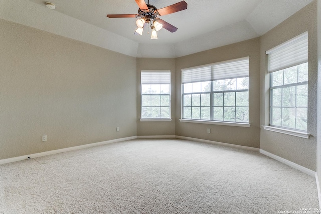 carpeted empty room featuring ceiling fan, baseboards, and a textured wall