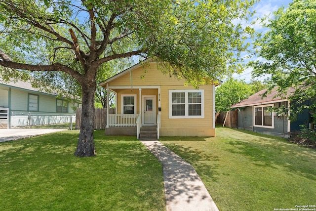 view of front facade featuring fence, a porch, and a front lawn