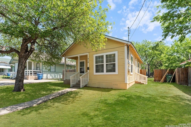 view of front facade with a front lawn, crawl space, and fence