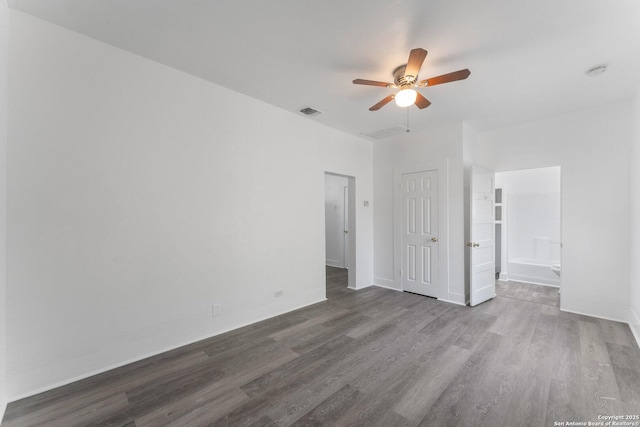 unfurnished bedroom with dark wood finished floors, baseboards, visible vents, a ceiling fan, and connected bathroom