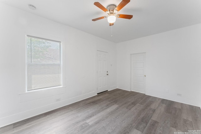 unfurnished room with wood finished floors, a ceiling fan, and baseboards