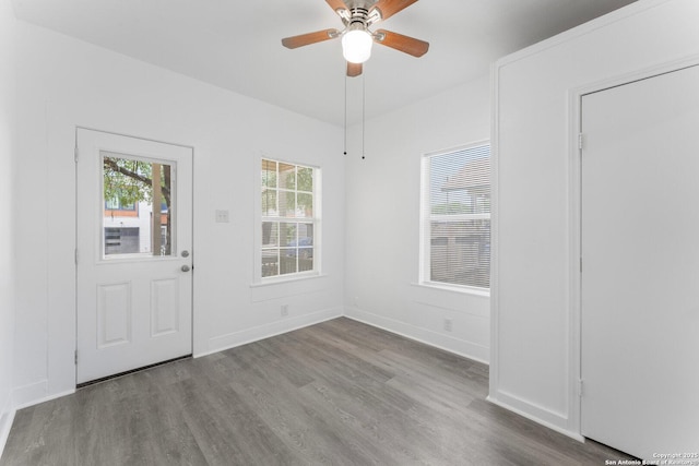 interior space featuring wood finished floors, baseboards, and ceiling fan