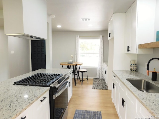 6023 Lark Valley Dr, San Antonio, TX 78242 - kitchen featuring a sink, stainless steel gas range, light wood-type flooring, light stone countertops, and visible vents