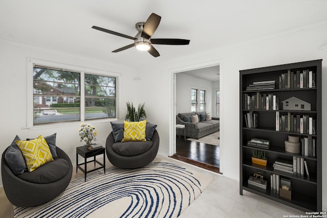 sitting room featuring a ceiling fan and a healthy amount of sunlight