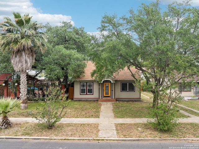 view of front of house featuring roof with shingles and a front yard