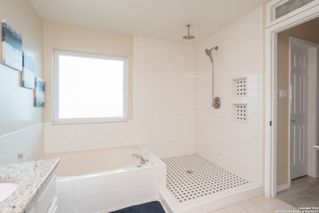 full bath with a garden tub, vanity, and a tile shower