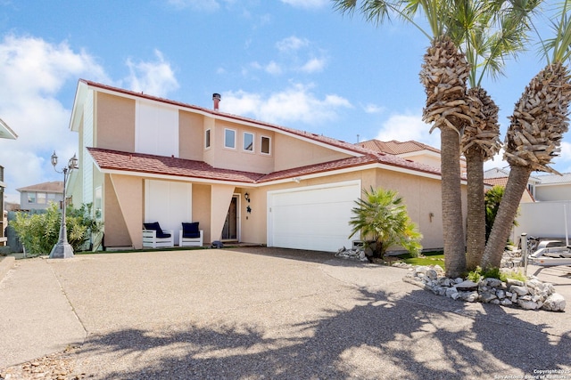 view of front facade featuring a garage, a tile roof, driveway, and stucco siding