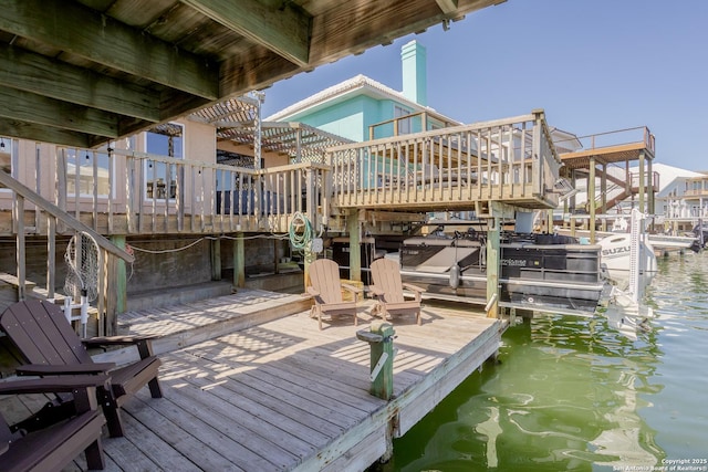 dock area with a deck with water view, stairway, and boat lift