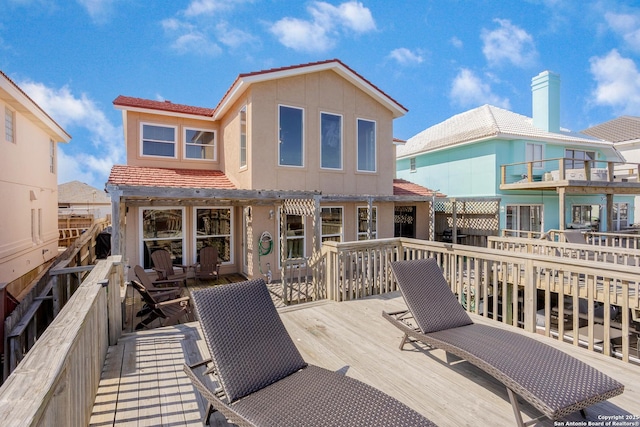 rear view of property with a wooden deck and stucco siding