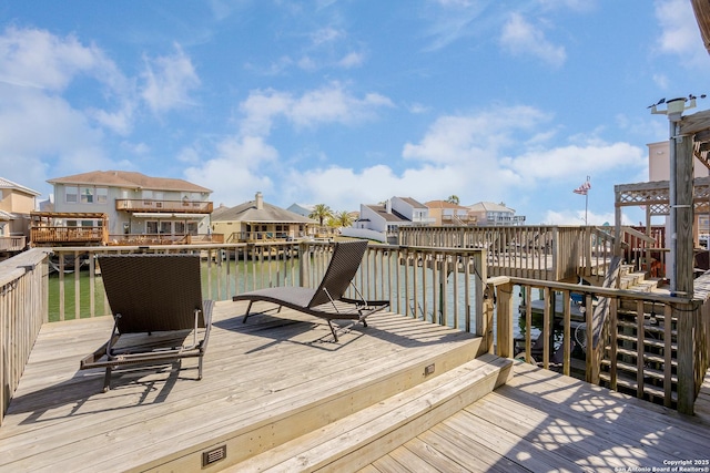 wooden deck featuring a water view and a residential view