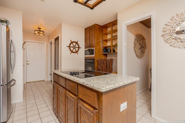 kitchen with brown cabinetry, black appliances, a center island, and light tile patterned floors