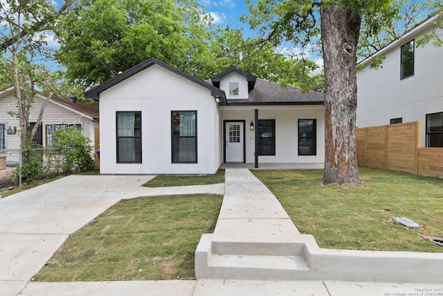 bungalow-style house featuring fence, a shingled roof, stucco siding, covered porch, and a front yard