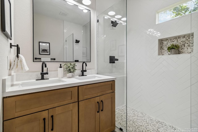 full bath featuring walk in shower, a sink, and double vanity