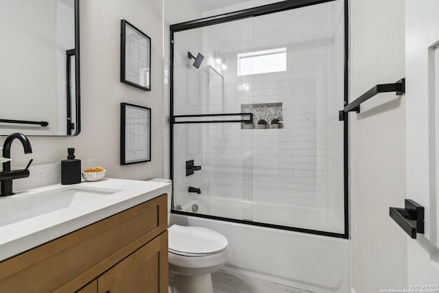 bathroom featuring toilet, vanity, and bath / shower combo with glass door