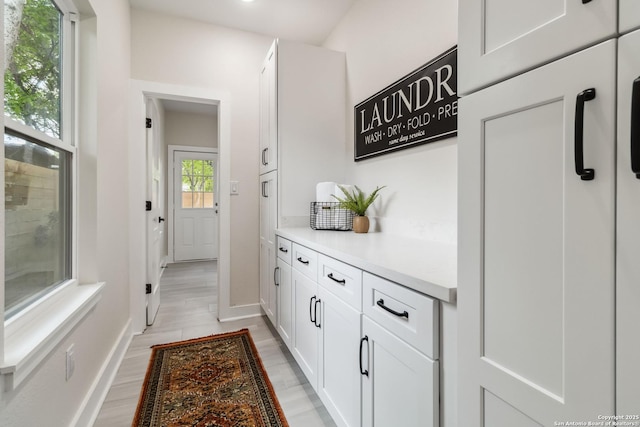 interior space with baseboards and light wood finished floors