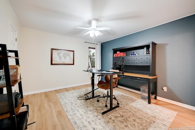 home office with light wood-style floors, a ceiling fan, and baseboards