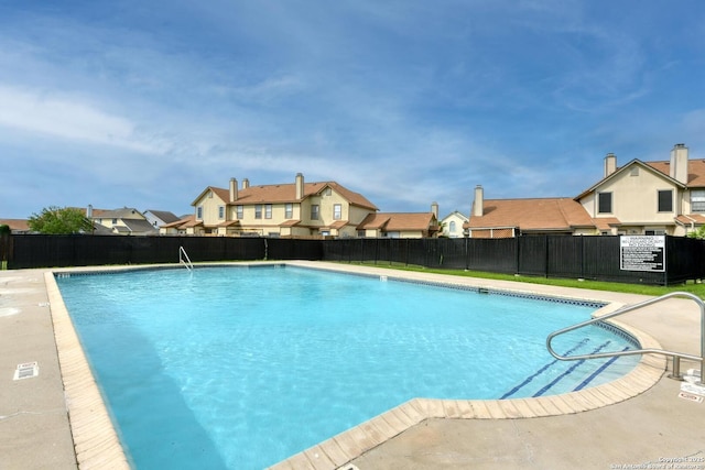 pool with a residential view and fence