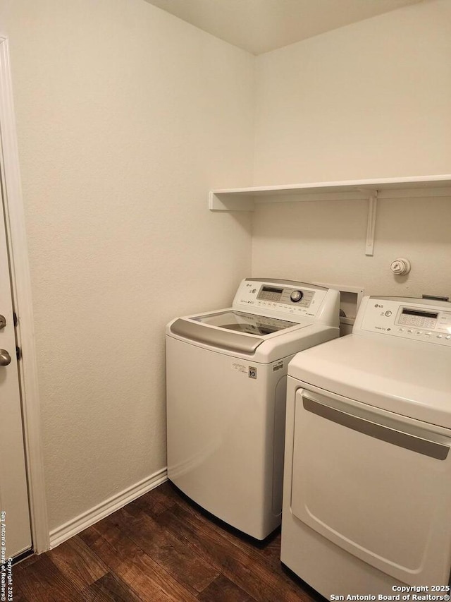 laundry area with washing machine and dryer, baseboards, laundry area, and dark wood-style flooring
