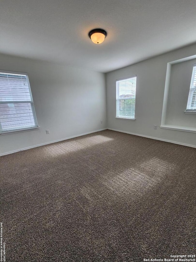 carpeted spare room featuring baseboards