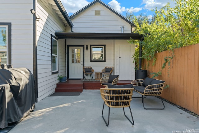 rear view of property with covered porch, a patio area, fence, and outdoor lounge area