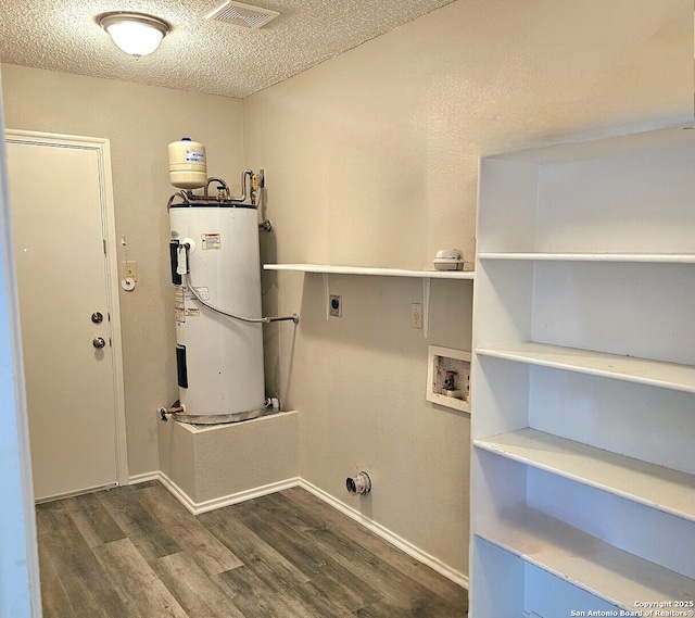 clothes washing area with electric dryer hookup, wood finished floors, water heater, and laundry area
