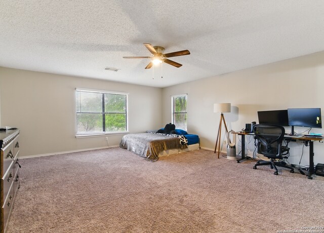 bedroom with a textured ceiling, carpet floors, visible vents, and multiple windows