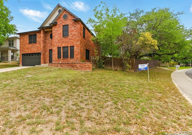 view of front of house with concrete driveway, a front lawn, an attached garage, fence, and brick siding