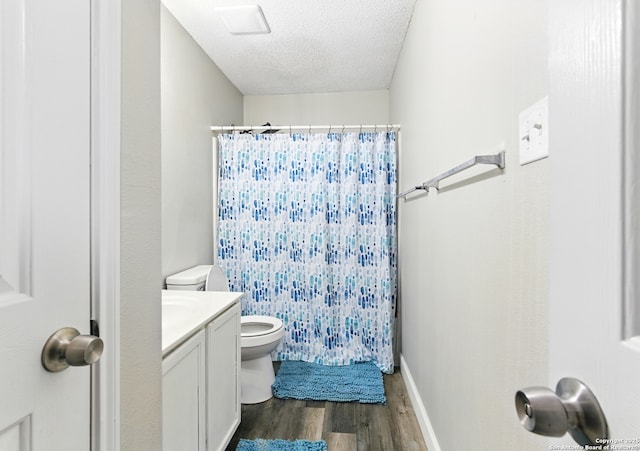 bathroom featuring a shower with curtain, a textured ceiling, toilet, wood finished floors, and vanity
