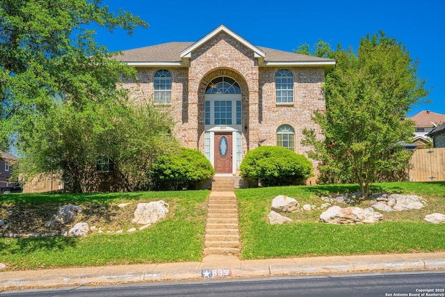 839 Stoneway, San Antonio, TX 78258 - traditional-style house with brick siding, a front yard, and fence
