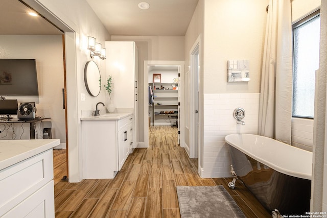 177 E Short Meadow Dr, Lytle, TX 78052 - full bathroom with a soaking tub, vanity, wood finished floors, and tile walls