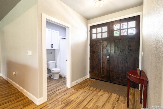177 E Short Meadow Dr, Lytle, TX 78052 - entryway featuring light wood-style floors, a textured wall, and baseboards