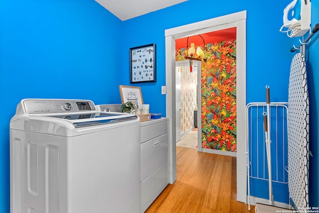 laundry room featuring light wood-style floors, baseboards, washer and dryer, and laundry area
