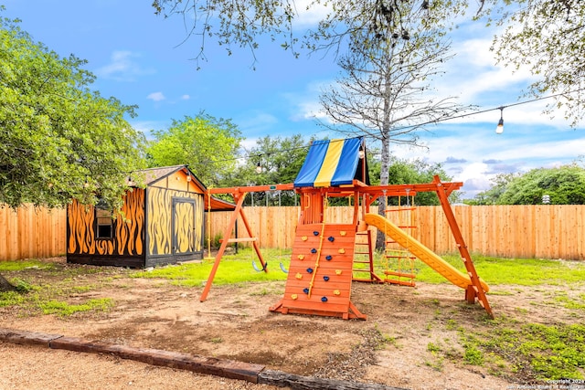 view of playground with a storage shed, an outbuilding, and a fenced backyard