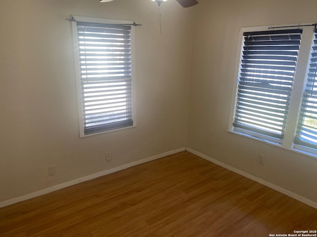 unfurnished room featuring ceiling fan, baseboards, and wood finished floors