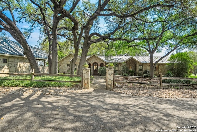 2802 State Highway 46, New Braunfels, TX 78132 - view of front of home featuring stone siding, a standing seam roof, a fenced front yard, and metal roof