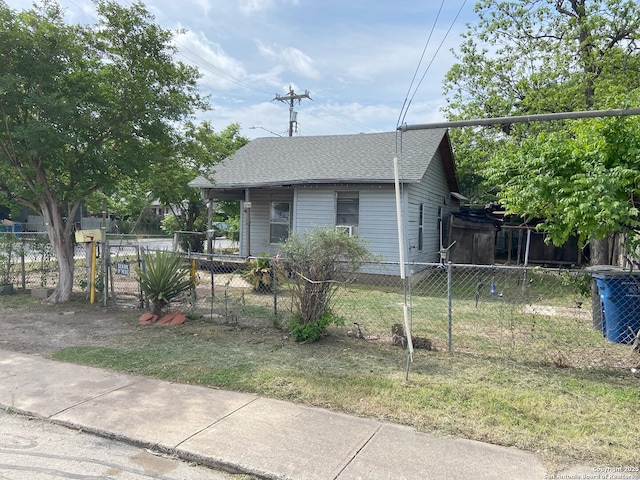 view of front of house featuring roof with shingles and fence