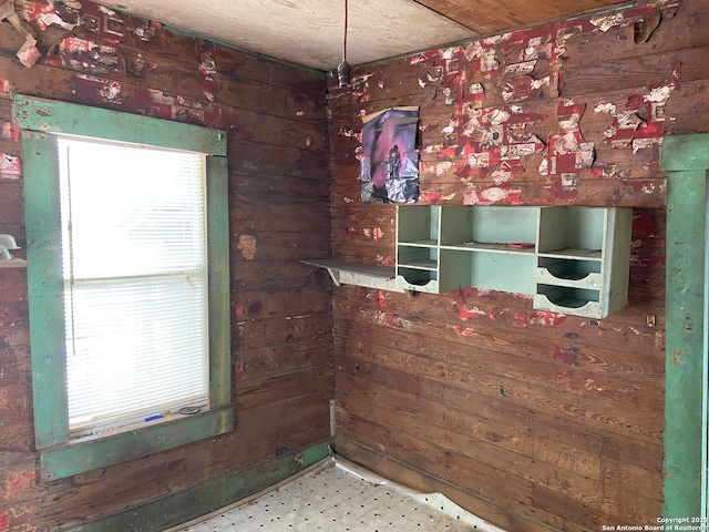 spare room with wooden walls and tile patterned floors