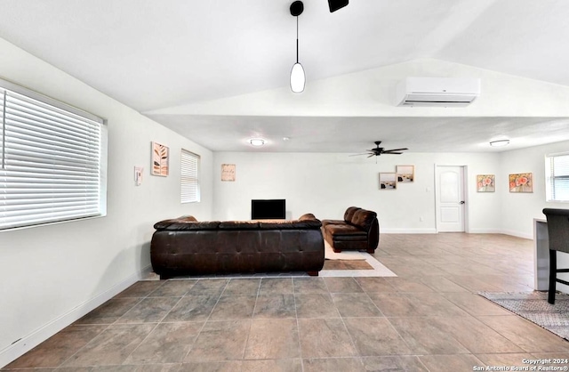 living room featuring vaulted ceiling, baseboards, a wall mounted AC, and a ceiling fan
