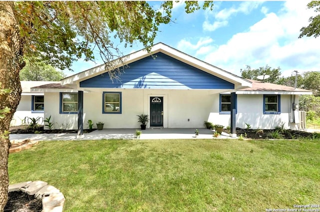 view of front of house featuring a patio, a front yard, and stucco siding