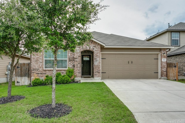 view of front of property with driveway, fence, brick siding, an attached garage, and a front yard