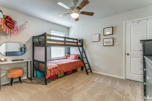 bedroom with ceiling fan, baseboards, carpet flooring, and a textured ceiling