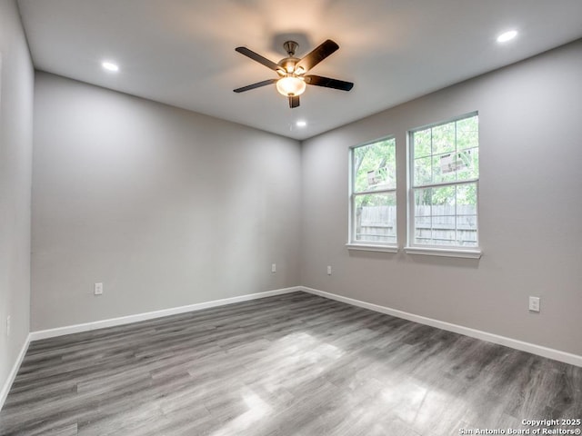 unfurnished room with recessed lighting, wood finished floors, a ceiling fan, and baseboards