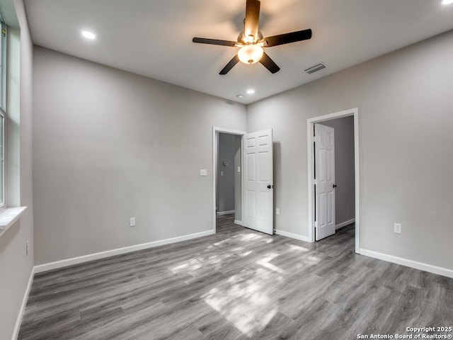 unfurnished bedroom featuring baseboards, wood finished floors, visible vents, and recessed lighting