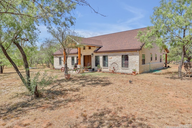 745 County Road 2645, Moore, TX 78057 - view of front of property featuring stone siding, a shingled roof, and a patio
