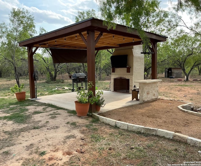 745 County Road 2645, Moore, TX 78057 - view of patio with a gazebo, grilling area, exterior fireplace, and a carport