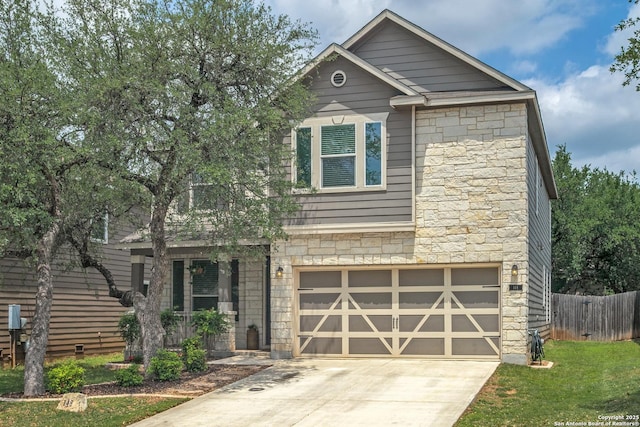 view of front of property featuring stone siding, an attached garage, driveway, and fence