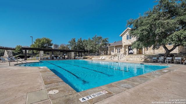 pool featuring a pergola and a patio area