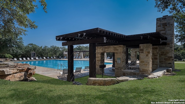 pool with a patio area and a lawn