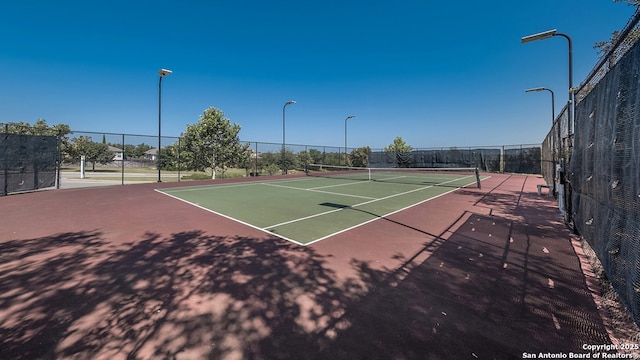 view of tennis court with fence