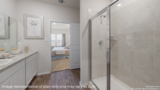 ensuite bathroom featuring wood finished floors, visible vents, vanity, a stall shower, and ensuite bathroom